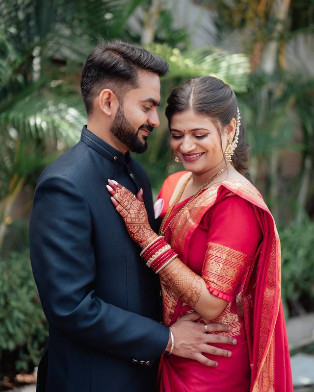 Bride in a red saree with henna, bridal makeup by Sonali Sarode