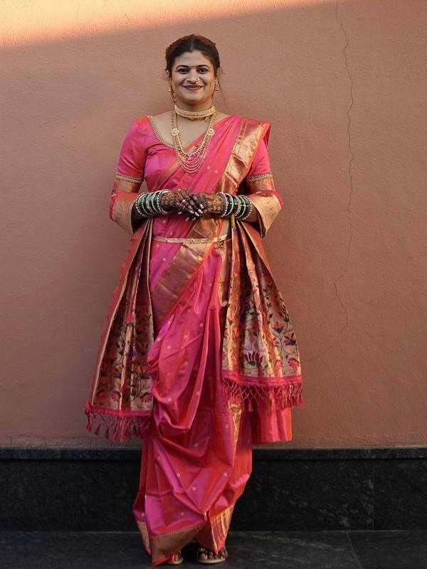 Nauvari bridal look in pink against a sunlit wall, saree draping by Sonali Sarode